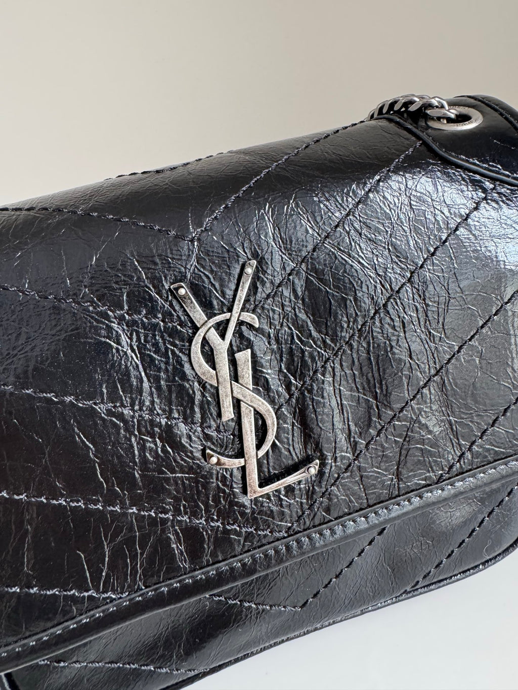 YSL dark leather shoulder bag front flap with YSL logo hardware centerpiece