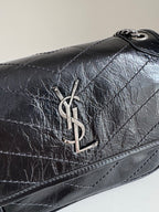 YSL dark leather shoulder bag front flap with YSL logo hardware centerpiece