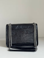 YSL dark leather shoulder bag with front flap, chain strap, and stitched front panel