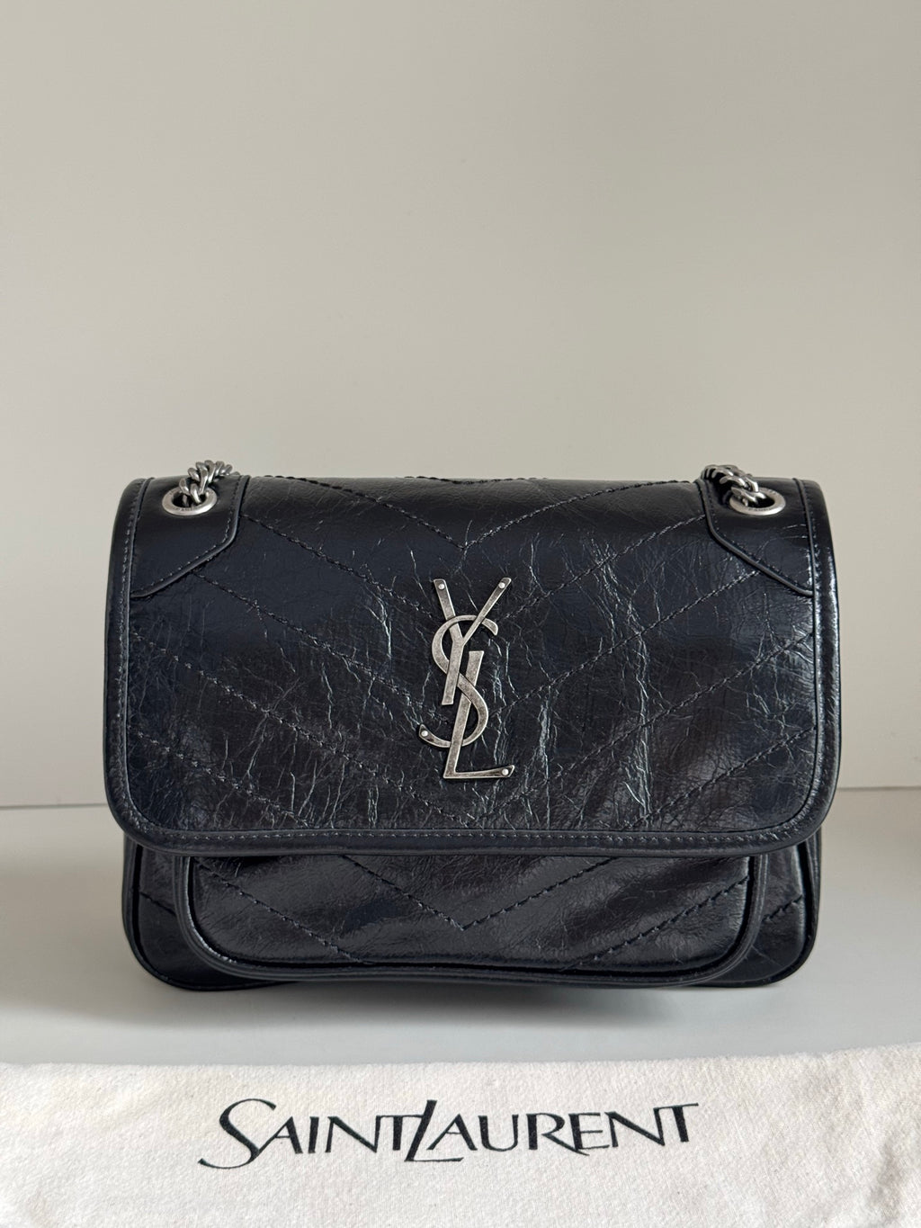 YSL dark leather shoulder bag with YSL logo on front flap and chain strap