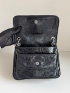 YSL dark leather bag with front patch pocket, snap buttons, and chain pull