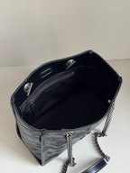Dark leather tote bag interior view with zip pocket and chain strap