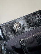 Dark leather tote bag close-up of zipper pocket and chain pull hardware