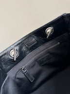 Dark leather tote bag top with chain handle rings and zip pocket hardware
