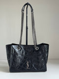 Dark leather tote bag with chain handles and YSL-style logo on the front