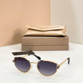 Bvlgari cat-eye sunglasses with dark purple lenses and gold-tone frame
