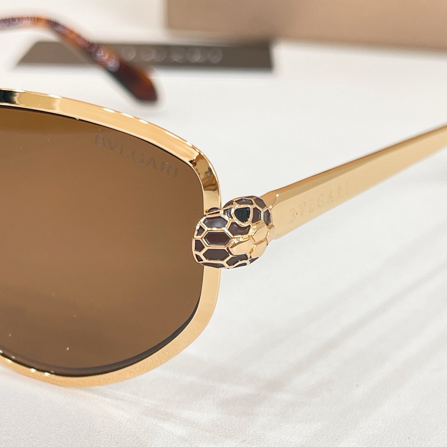Bvlgari cat-eye sunglasses close-up of gold-tone frame and dark lenses