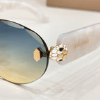 Bvlgari sunglasses close-up: round dark lenses with gold emblem hinge detail