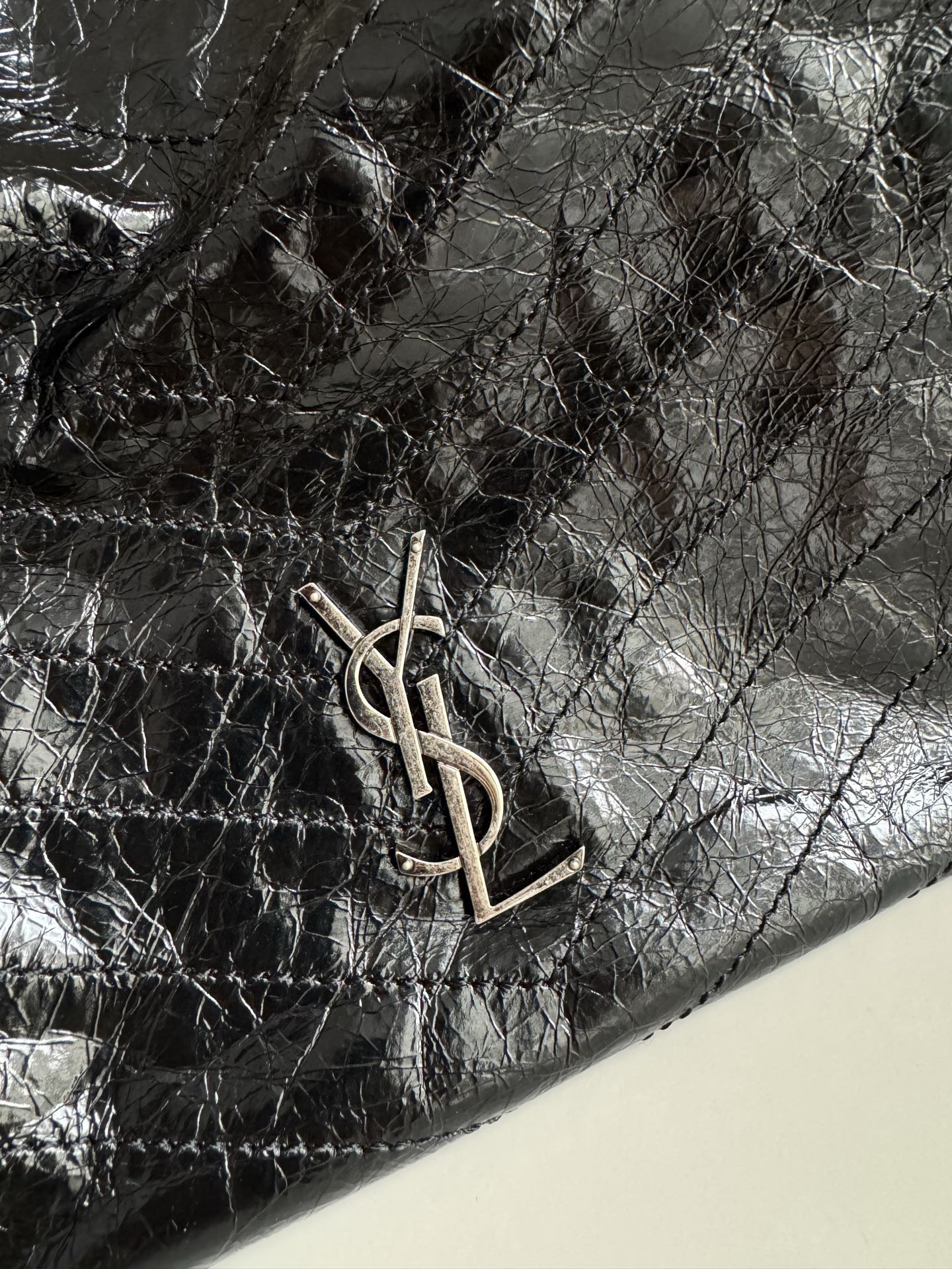 Black leather tote bag corner with YSL metal logo hardware