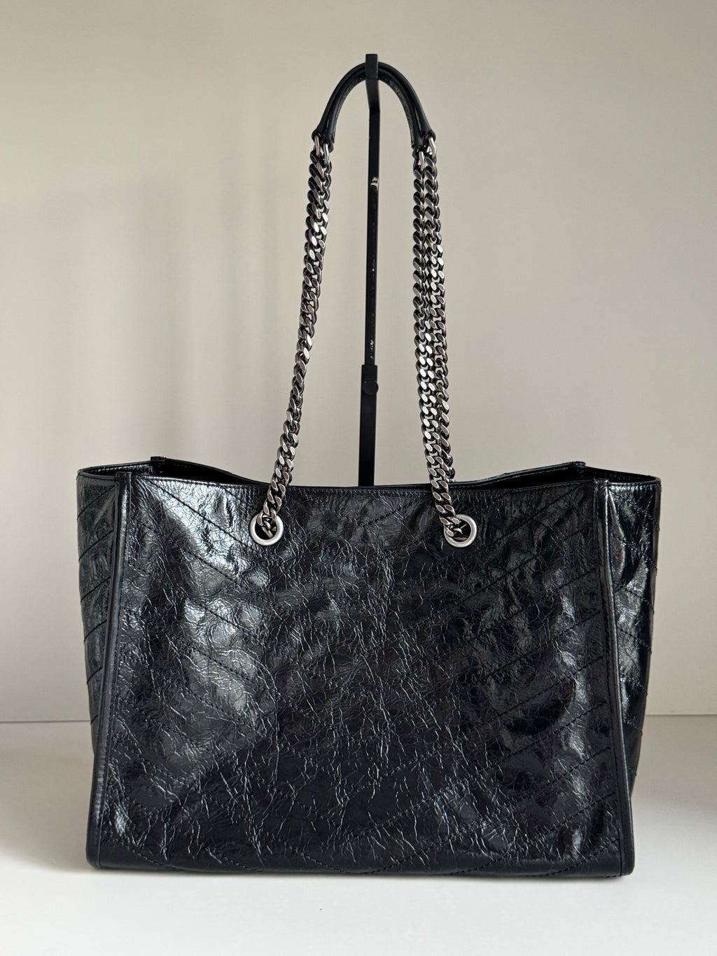 Black leather tote bag with chain shoulder straps and open top