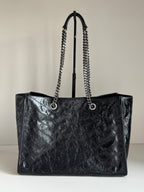 Black leather tote bag with chain shoulder straps and open top