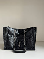 Black leather tote bag with chain handles and YSL logo front