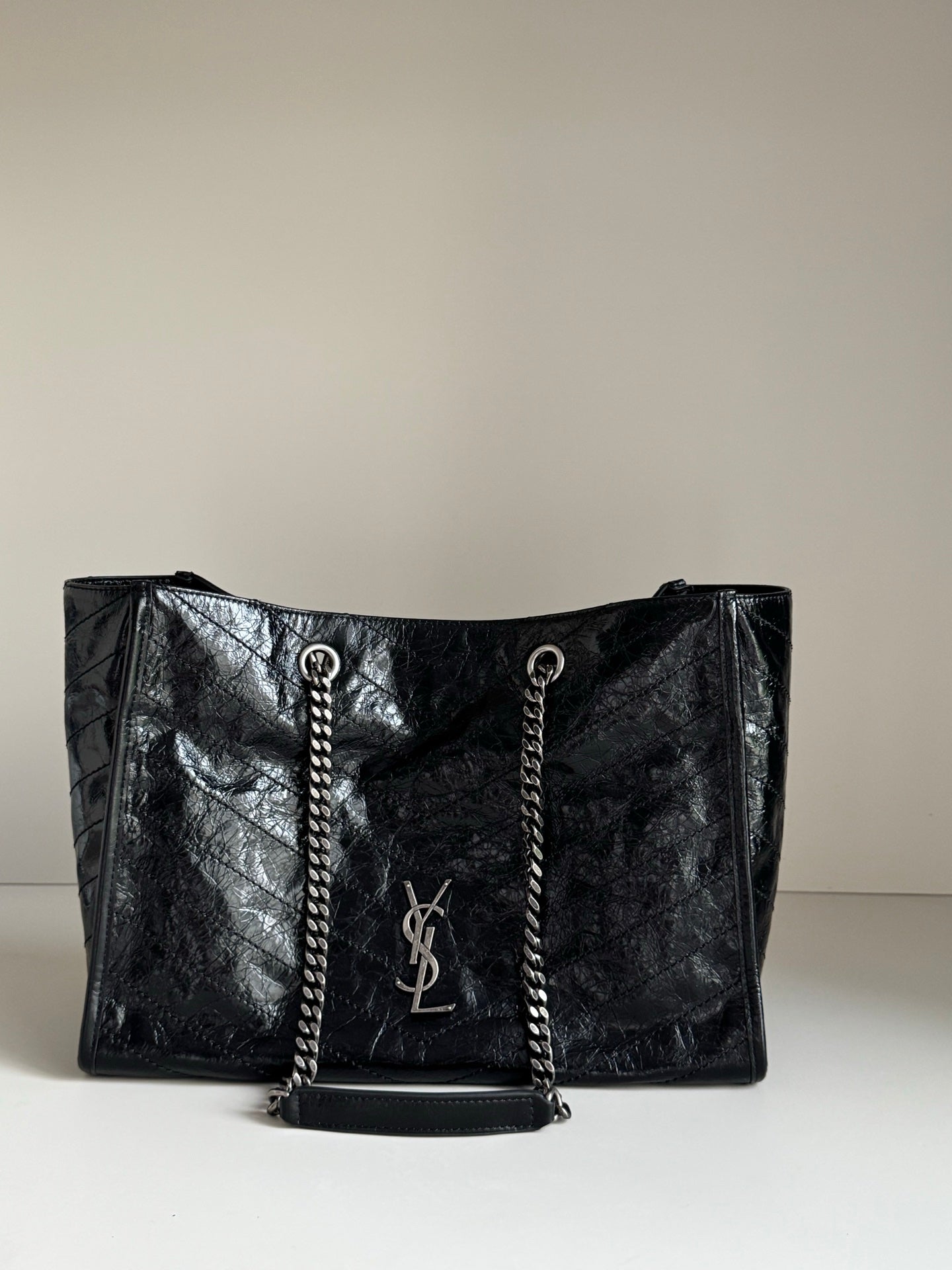 Black leather tote bag with chain handles and YSL logo front