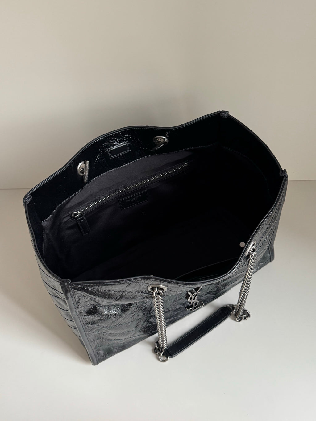 Black leather tote bag interior with chain strap and top edge trim