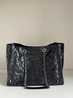 Black leather tote bag front view with chain handles and top opening