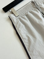 White shorts close-up: gathered waistband and side pocket opening