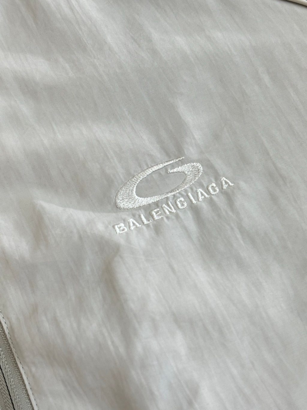 Balenciaga logo patch on light fabric, oval mark with text