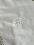 Balenciaga logo patch on light fabric, oval mark with text
