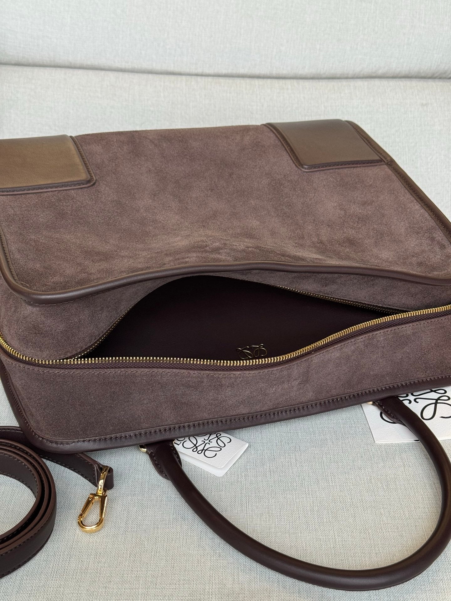 Loewe brown leather handbag with open top, gold-tone zipper, and inner pocket lining