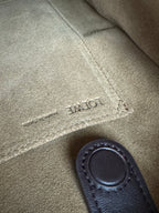 Loewe leather close-up with engraved logo text and stitched dark leather handle tab