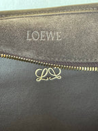 Loewe logo on brown leather near gold zipper with engraved monogram detail