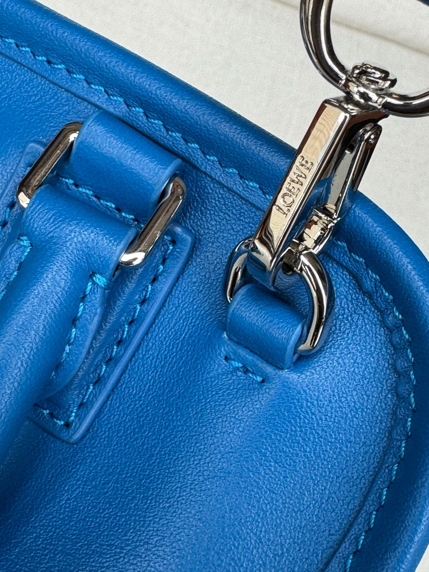 Loewe blue leather bag close-up of metal D-rings, straps, and stitching