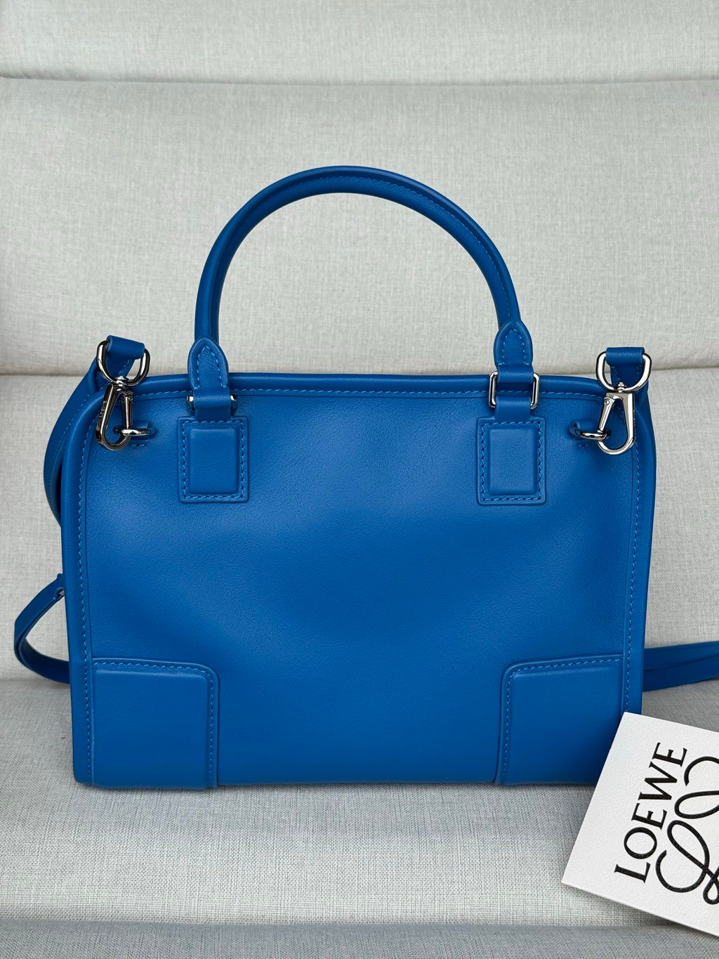 Loewe blue leather handbag with top handles, front patch pockets, and zip closure
