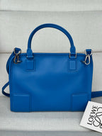 Loewe blue leather handbag with top handles, front patch pockets, and zip closure