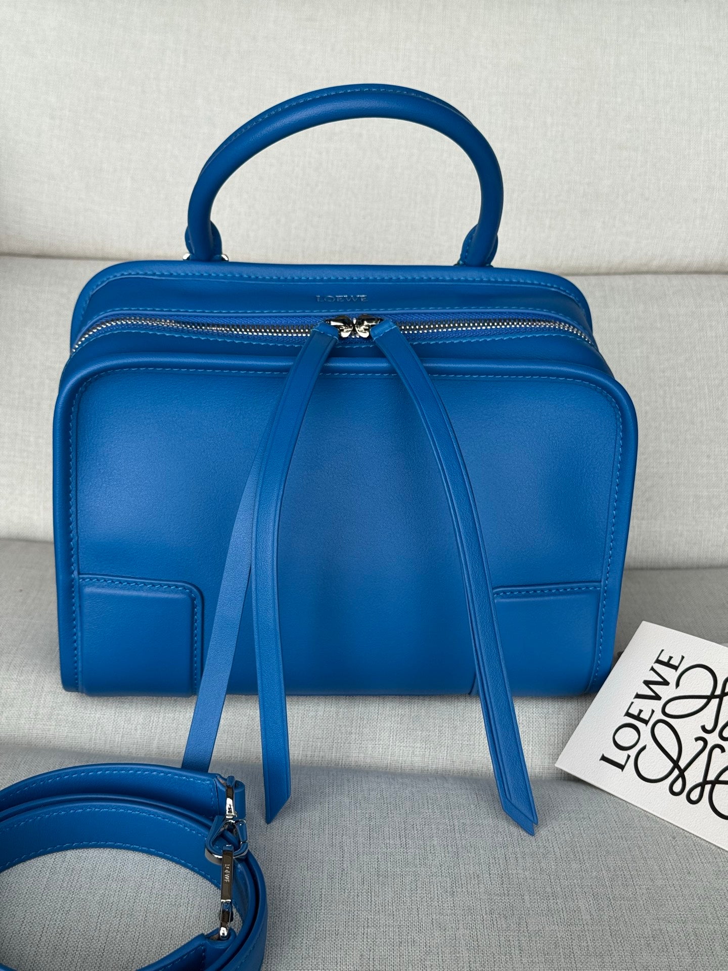 Loewe blue leather top-handle bag with front zip and long shoulder strap