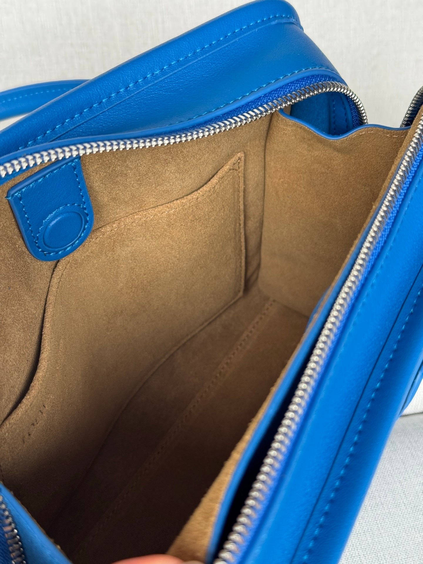 Loewe blue leather bag interior view with suede lining and zip closure