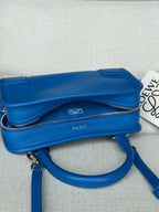 Blue leather crossbody bag with flap top, zip closure, and long shoulder strap