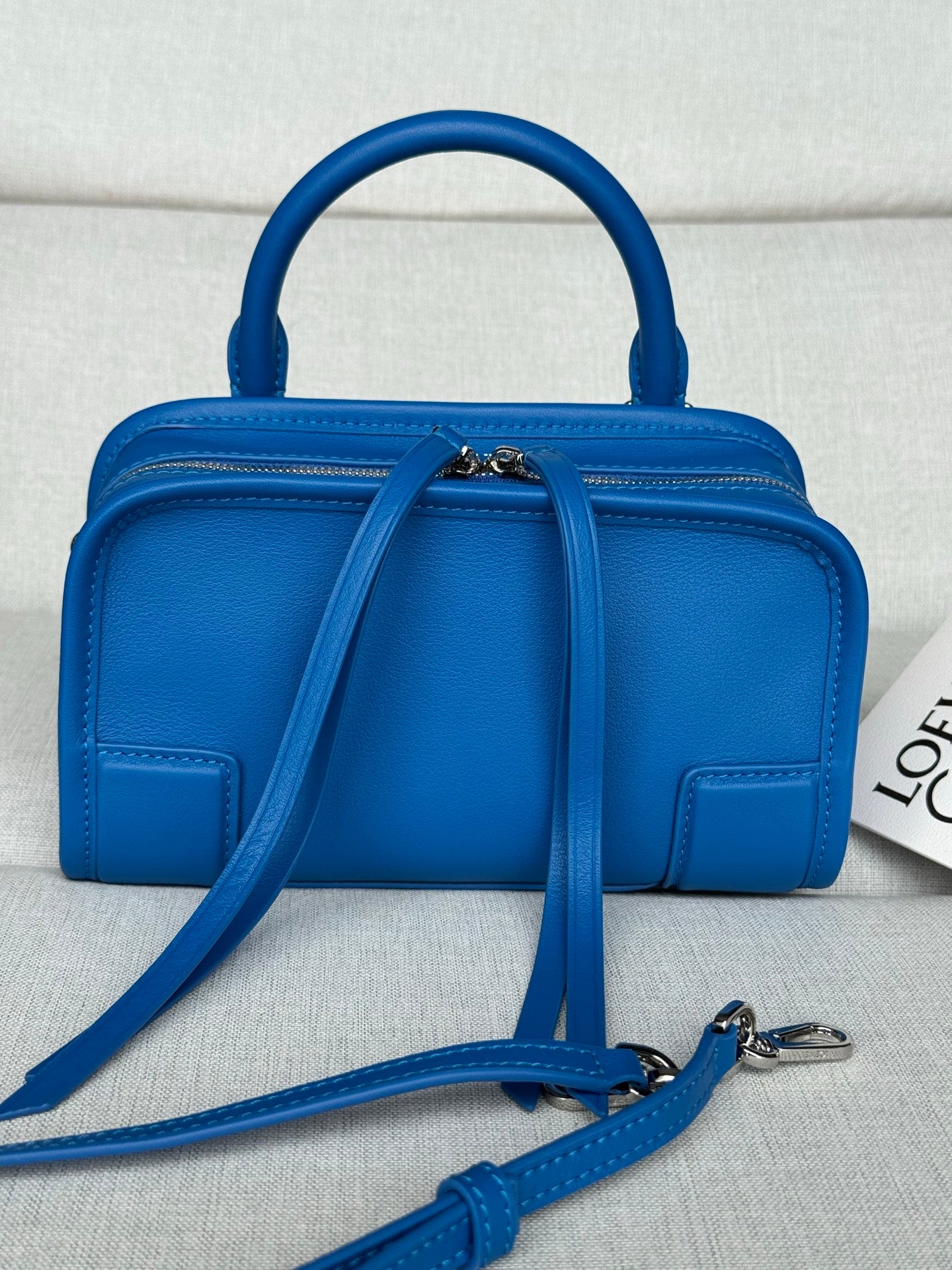 Loewe blue leather top-handle bag with front flap, zipper, and crossbody strap