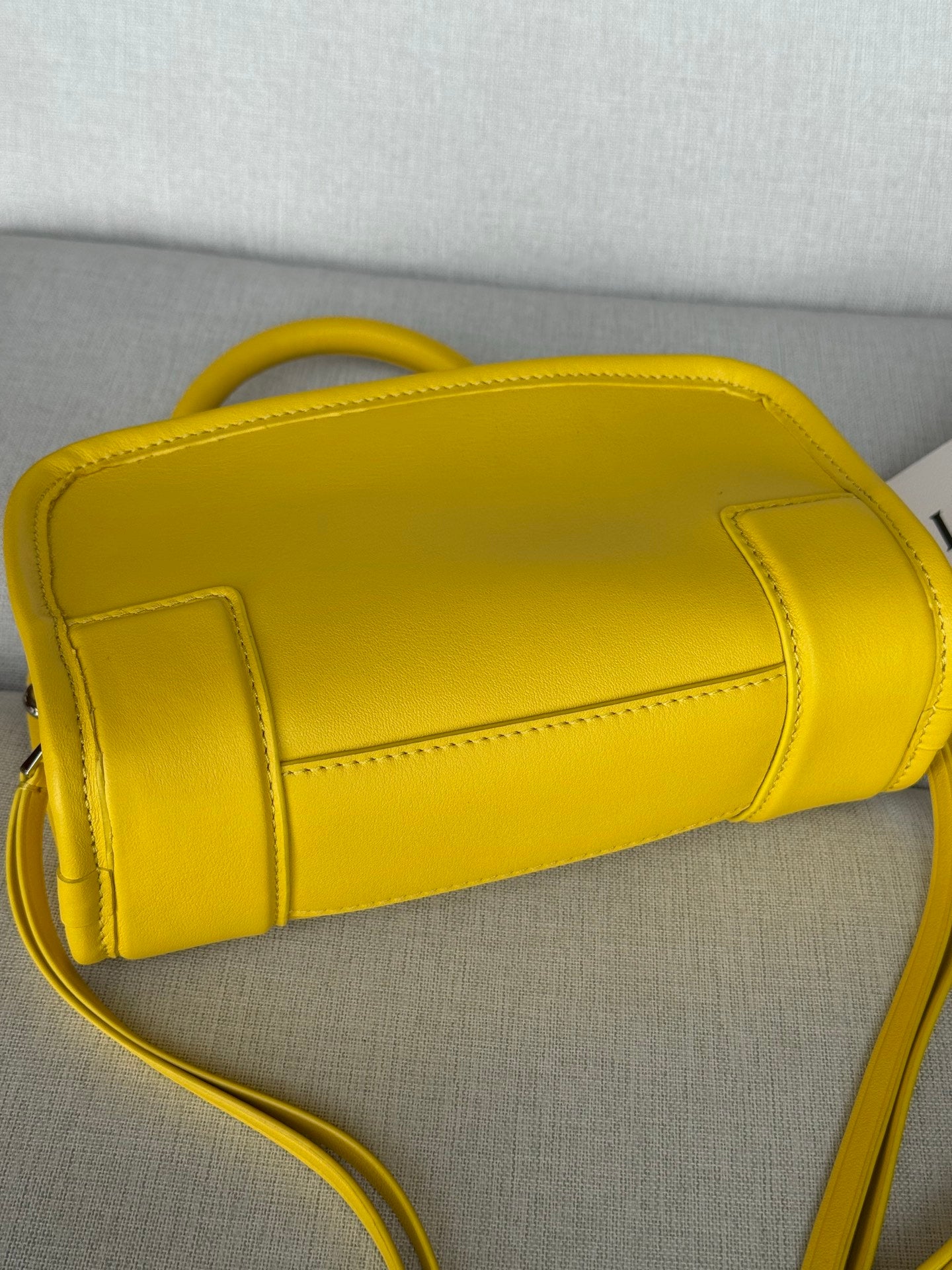 Yellow leather bag exterior with stitched panel seams and crossbody strap