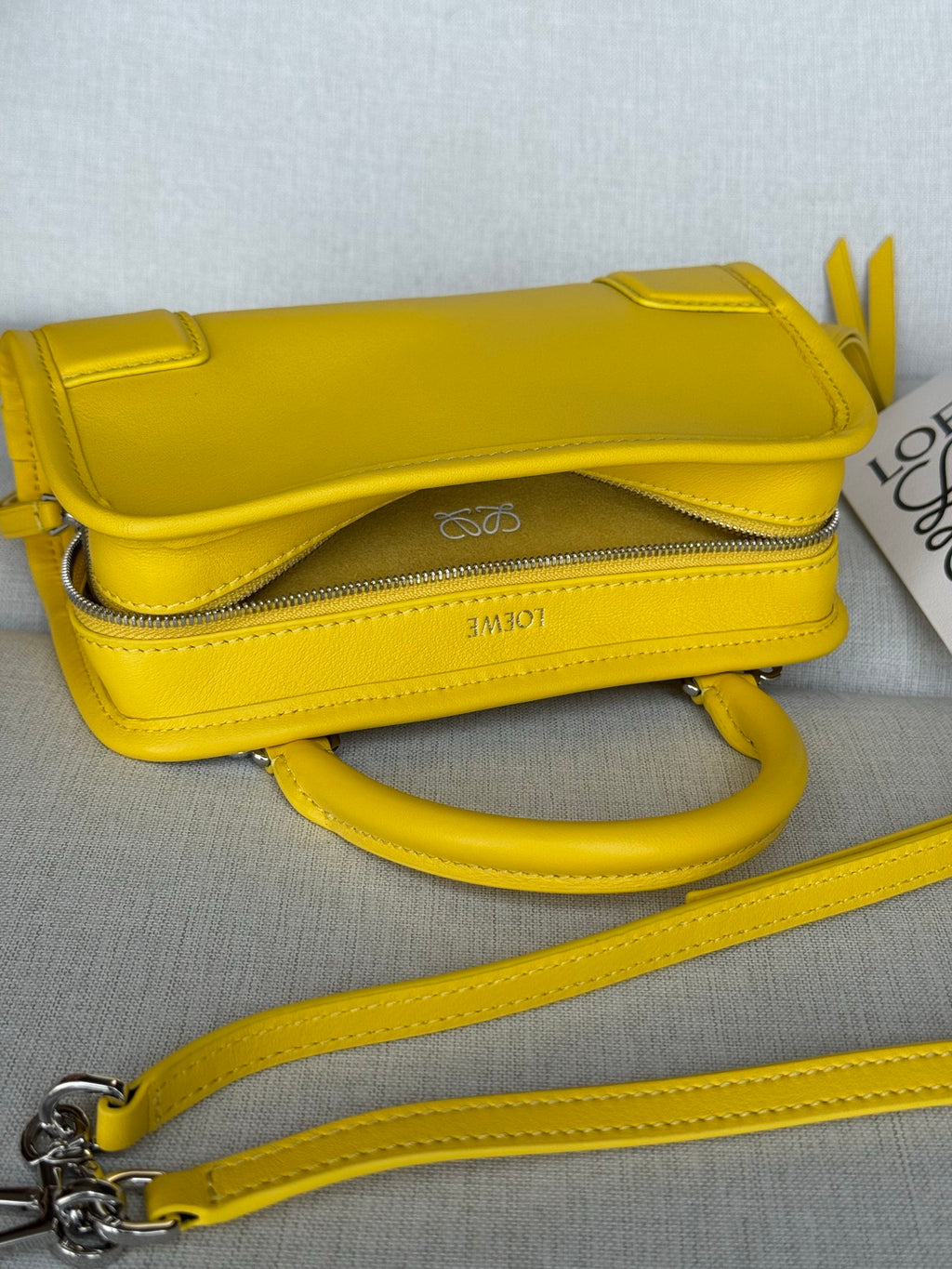 Yellow leather mini shoulder bag with front flap, long strap, and metal hardware