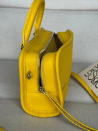 Yellow leather crossbody bag with zip pocket and polished metal zipper pulls