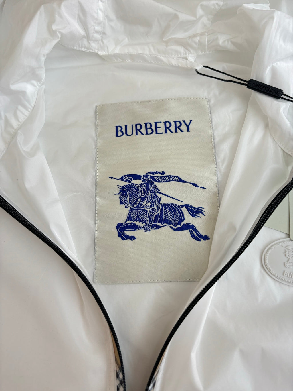 Burberry white jacket label: blue logo text and horse emblem on inner panel