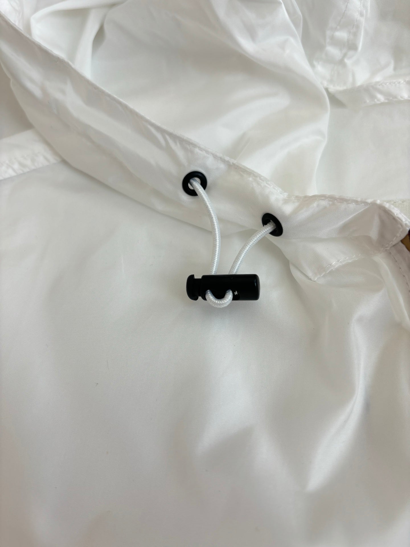 Burberry white windbreaker hood with black drawcords and toggle ends