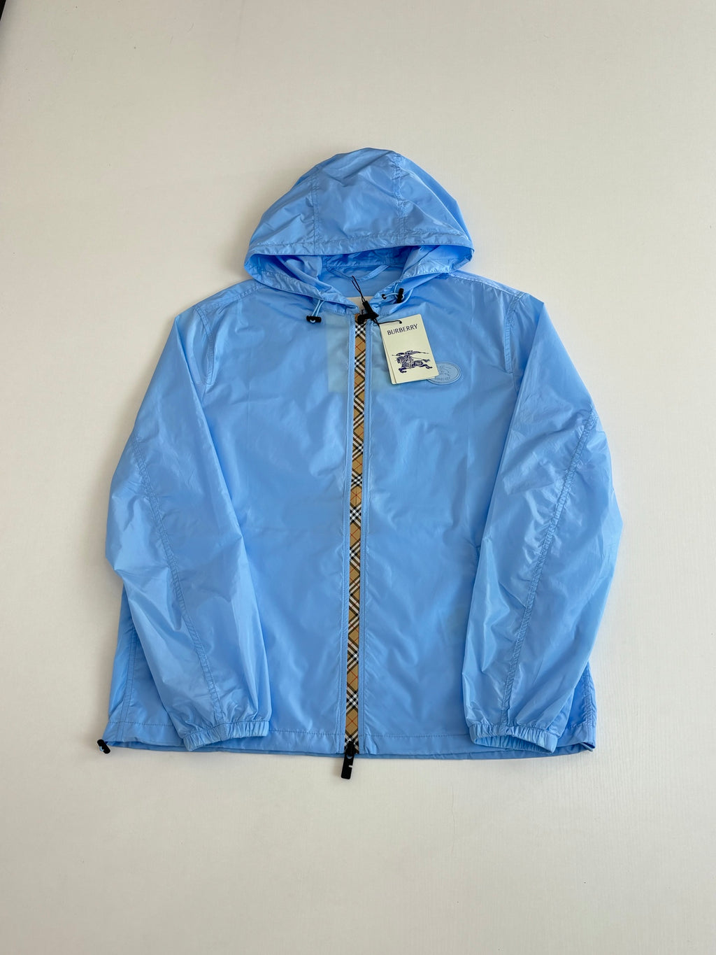 Blue hooded jacket laid flat, full front zip with Burberry tag