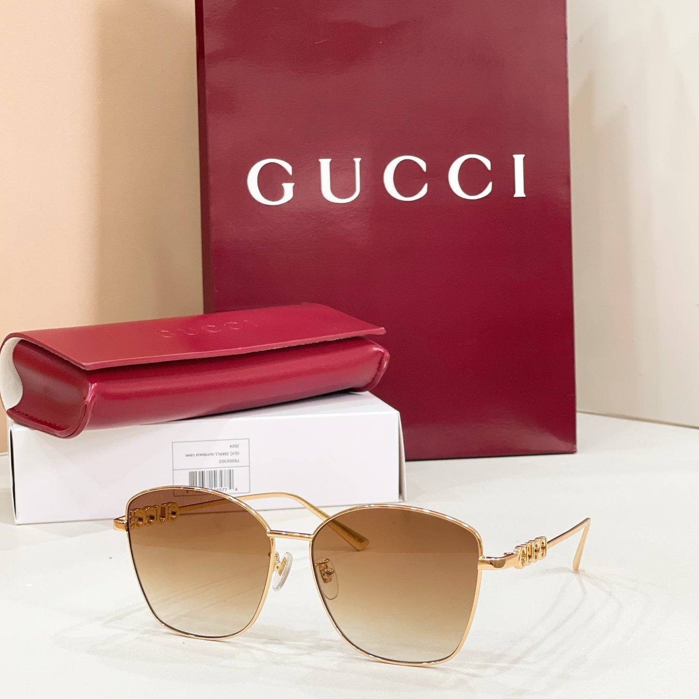 Sunglasses with gold metal frame and amber tinted lenses; cat-eye silhouette