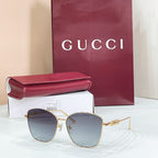 Gucci sunglasses with gold metal frame and light blue tinted lenses, cat-eye shape