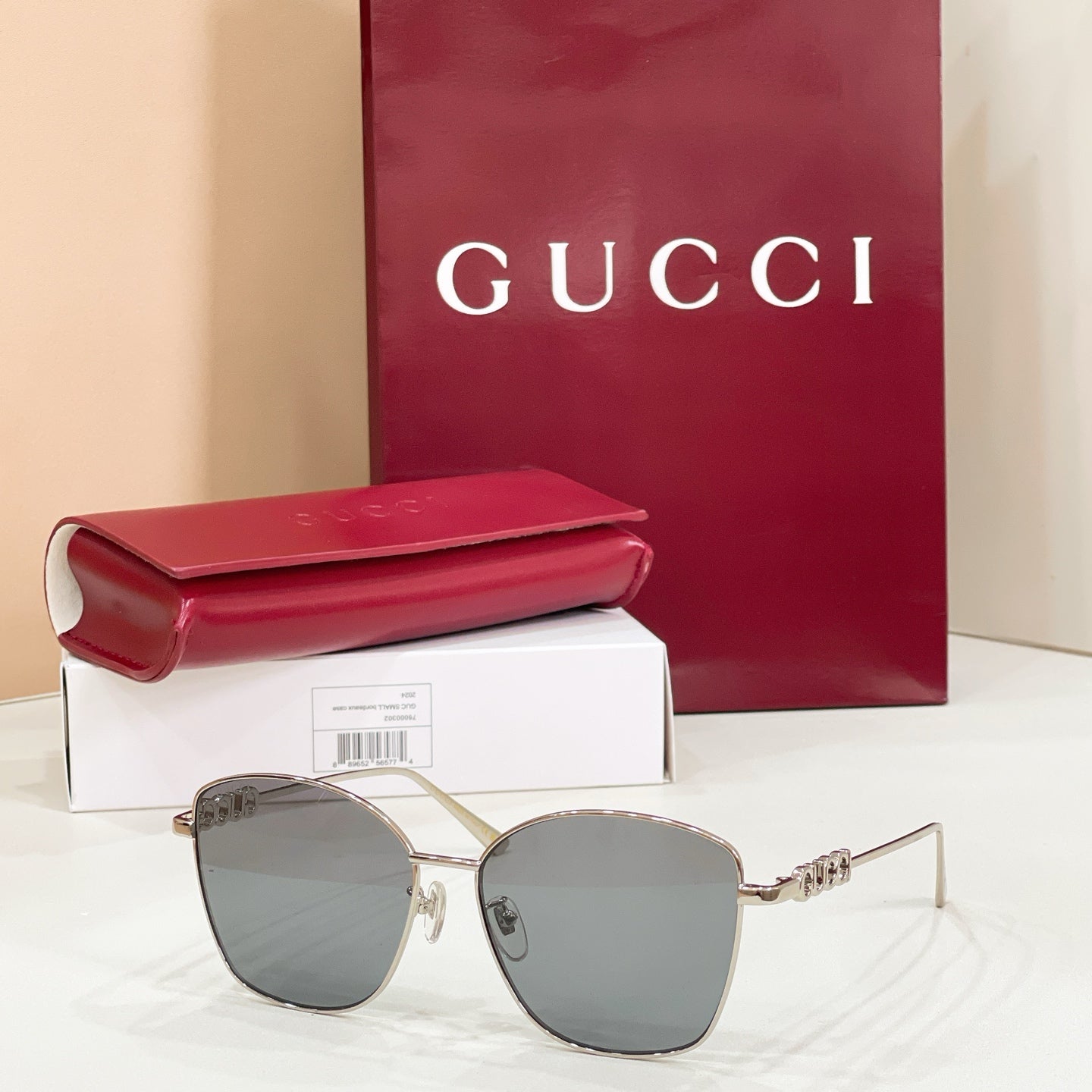 Sunglasses with gold metal frame and light blue tinted lenses; sleek cat-eye design