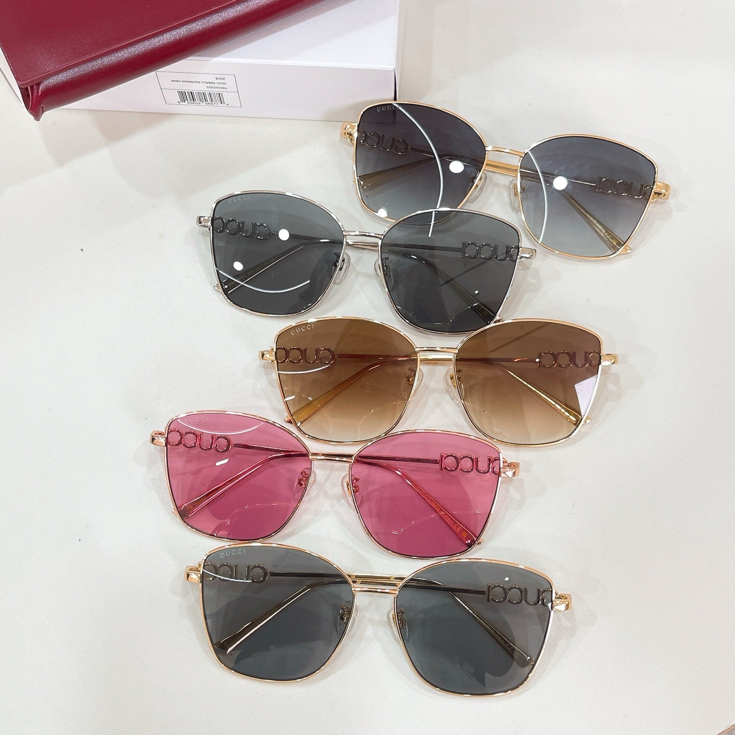 Assorted sunglasses with black, brown, and pink tinted lenses and gold frames