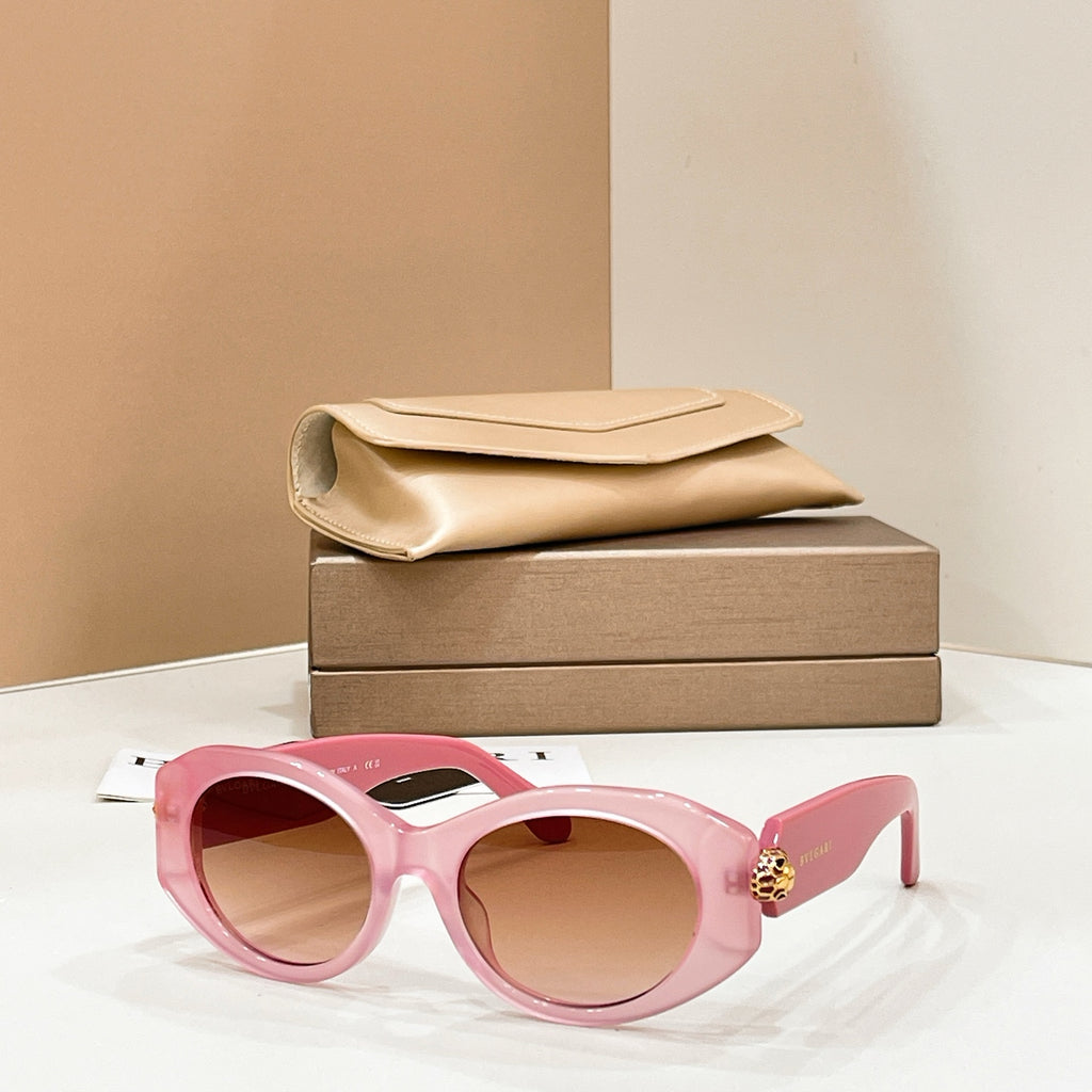 Bvlgari round sunglasses with pink frame and pink-tinted lenses, gold-toned charm on temple.