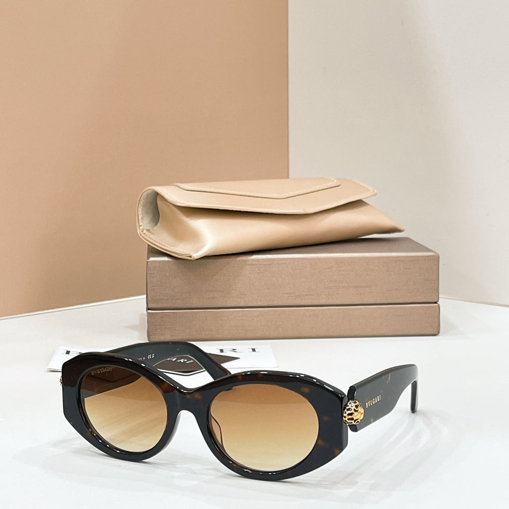 Bvlgari round sunglasses with black frame and warm tan-tinted lenses, gold-toned charm.