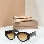 Bvlgari round sunglasses with black frame and warm tan-tinted lenses, gold-toned charm.