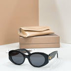 Bvlgari round sunglasses with black frame and dark lenses, gold-toned charm on temple.