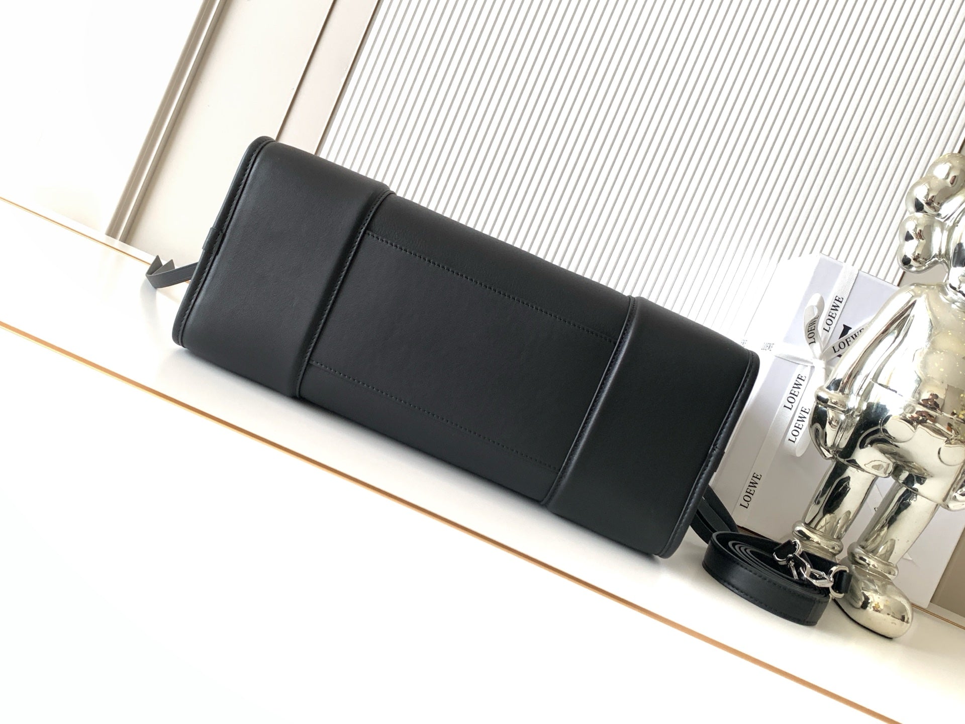 Loewe black leather long pouch bag with top strap and front seam detail