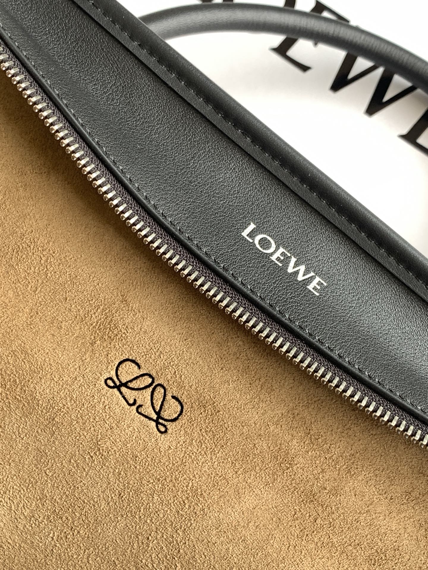 Black leather bag interior zipper track with Loewe label