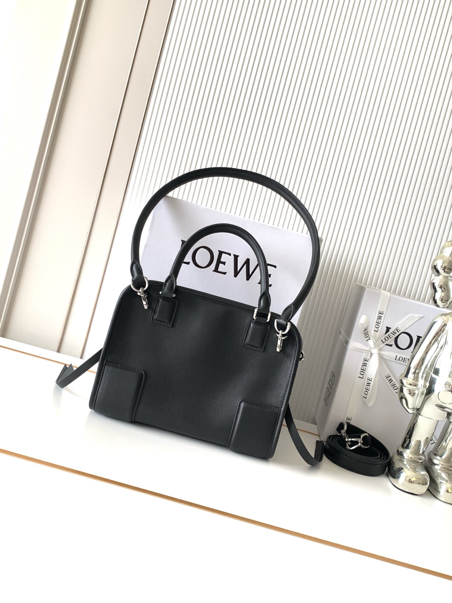 Black Loewe-branded top-handle bag with shoulder strap and gold hardware
