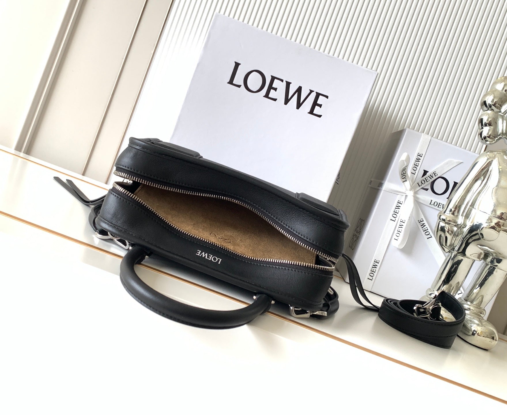 Black Loewe-branded zip bag with top zipper and crossbody strap